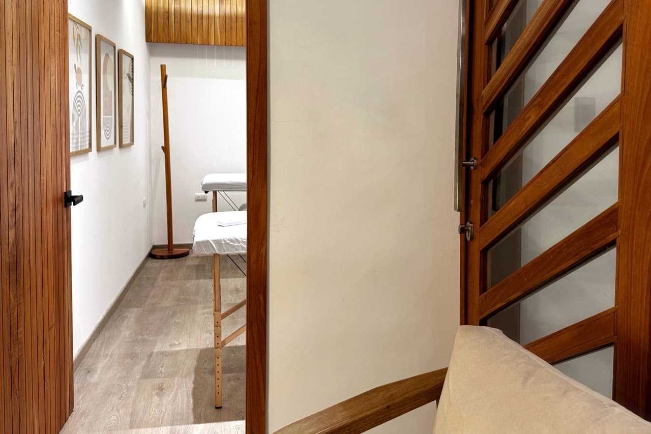 Fotografia, entrada al cuarto de masajes con puerta de madera y decoración relajante en la pared